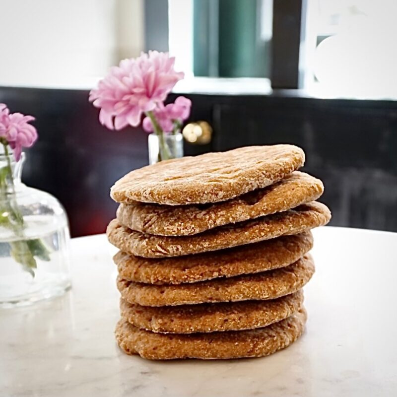 7 panini di segale su tavolo di marmo con fiori rosa dietro