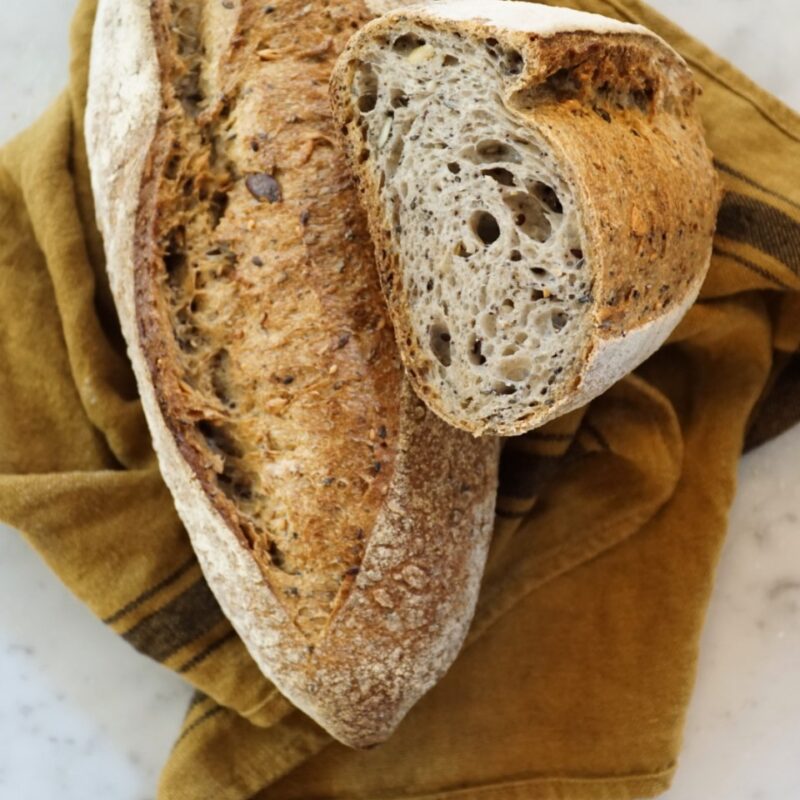 filone di pane e mezzo filone su strofinaccio color senape