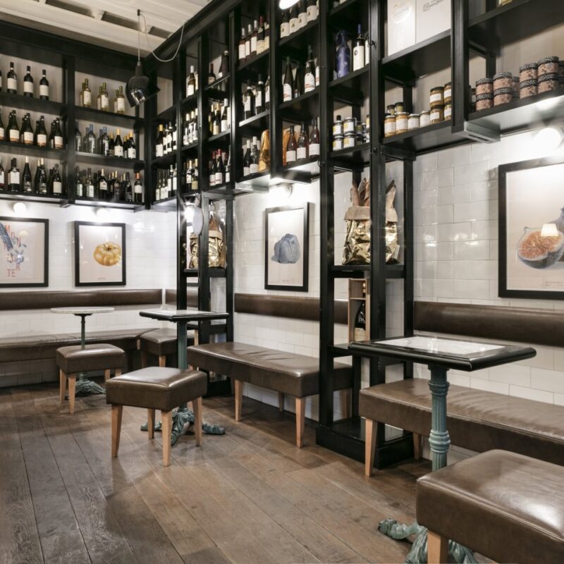 scaffali con prodotti enogastronomici, tavoli e sedie